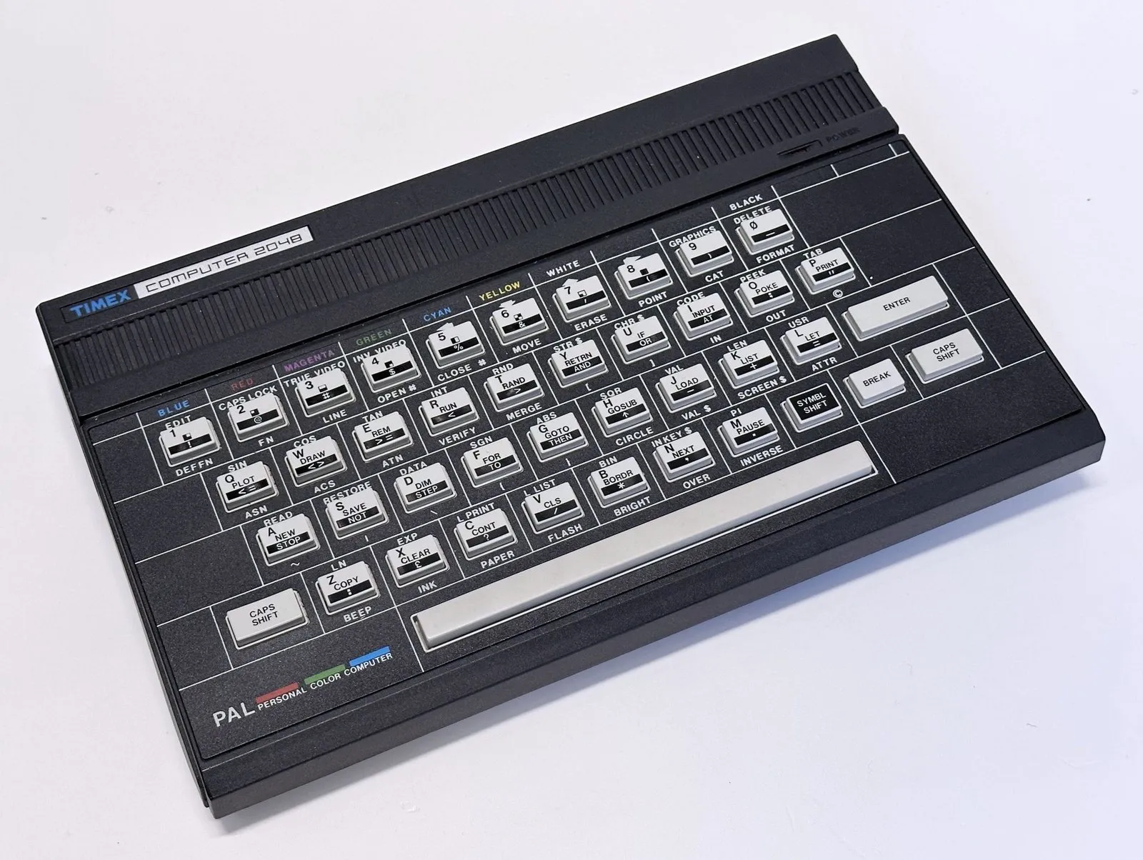 Timex Computer 2048 — чорний корпус із вентиляційною решіткою, напис «TIMEX COMPUTER 2048» і клавіатура з кольоровими позначками команд, вигляд під кутом