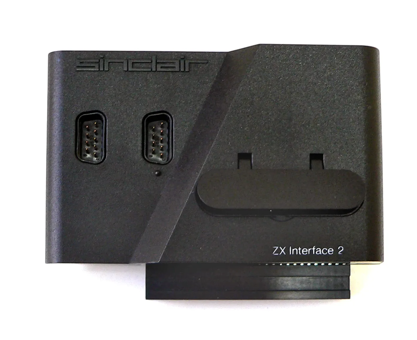 Sinclair ZX Interface 2 — чорний модуль із двома портами джойстиків, слотом для картриджа і написом «ZX Interface 2»