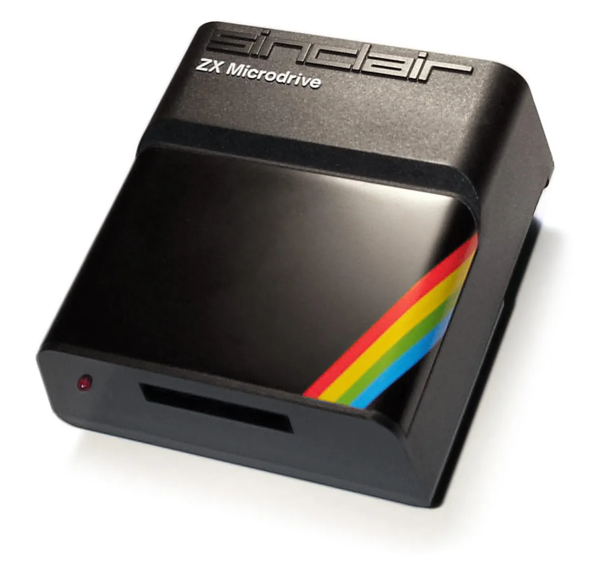 Sinclair ZX Microdrive — чорний накопичувач із написом «sinclair ZX Microdrive», веселковою смугою, щілиною для картриджа і червоним індикатором