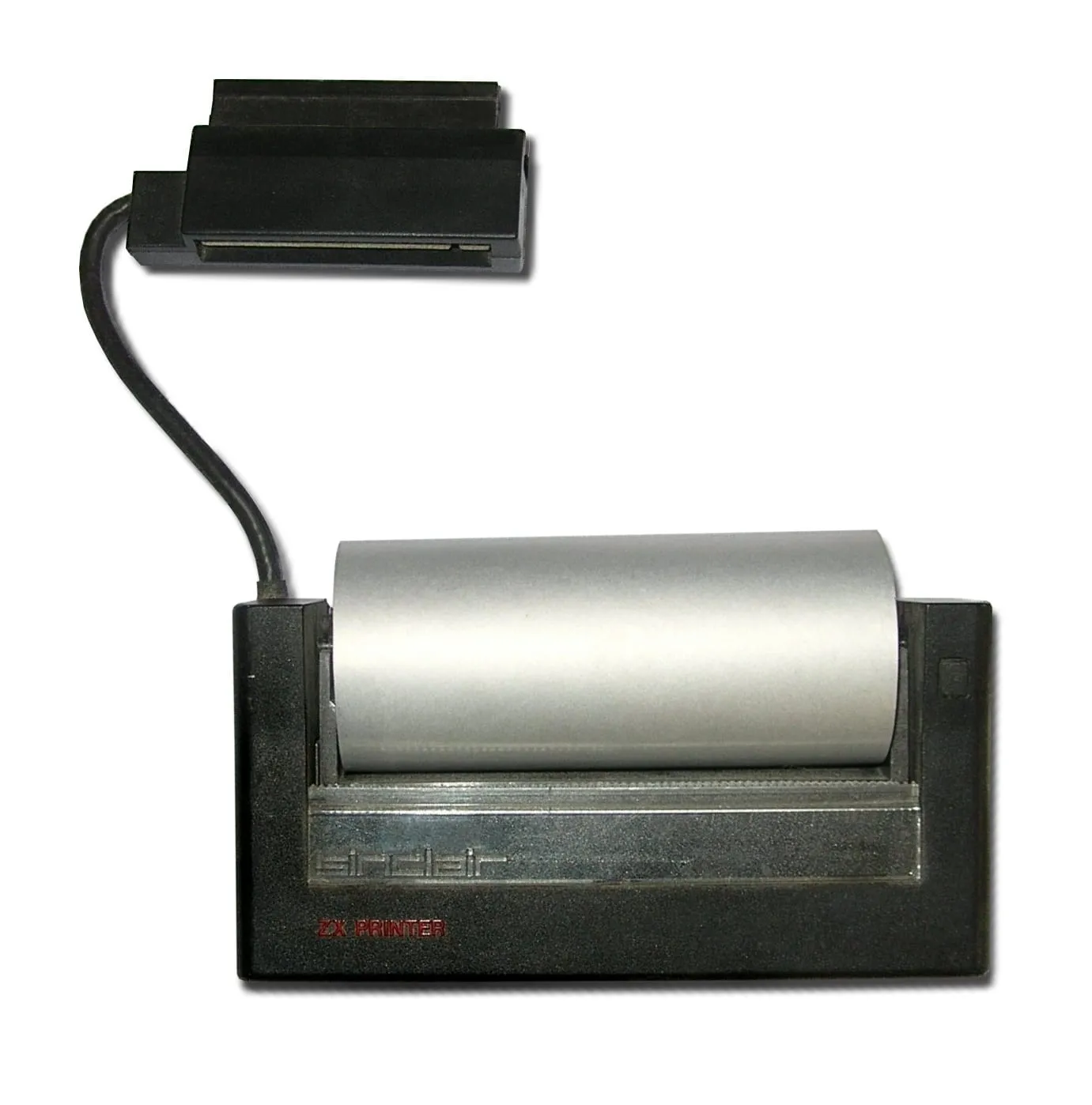 Sinclair ZX Printer — чорний блок із написом «sinclair ZX PRINTER» і рулоном сріблястого алюмінізованого паперу зверху; поряд запасний рулон